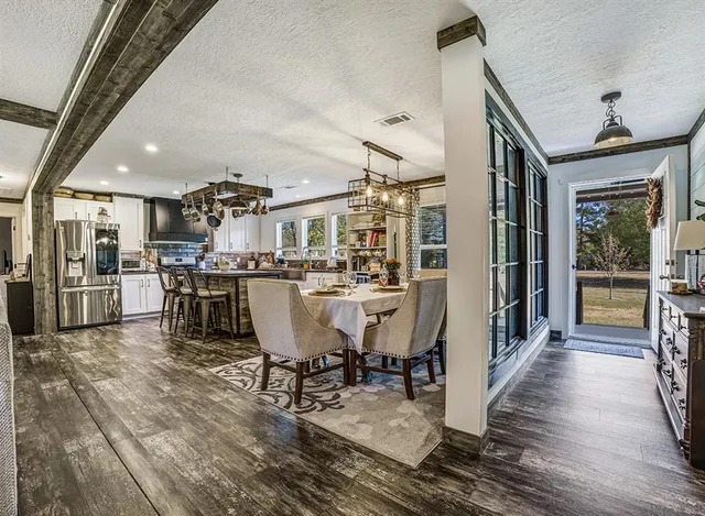 a dining room with stainless steel appliances a dining table chairs and view of kitchen