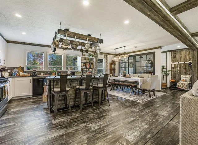 a kitchen with a dining table chairs stainless steel appliances and cabinets