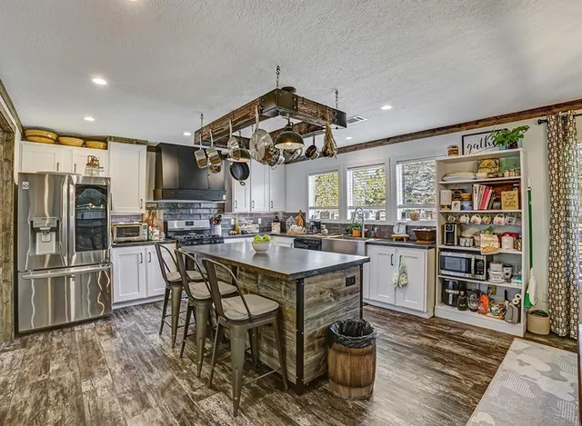 a kitchen with stainless steel appliances kitchen island granite countertop a table and chairs