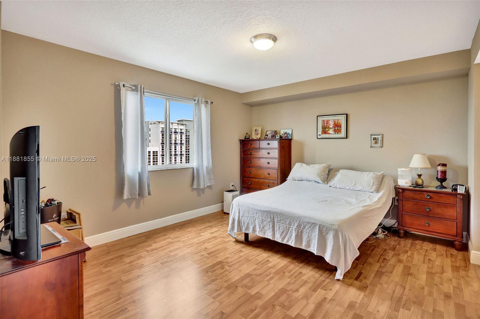 816 Northwest 11th Street, Unit 905 Miami, FL 33136 - Photo 5 of 14 a bedroom with a bed and a flat screen tv