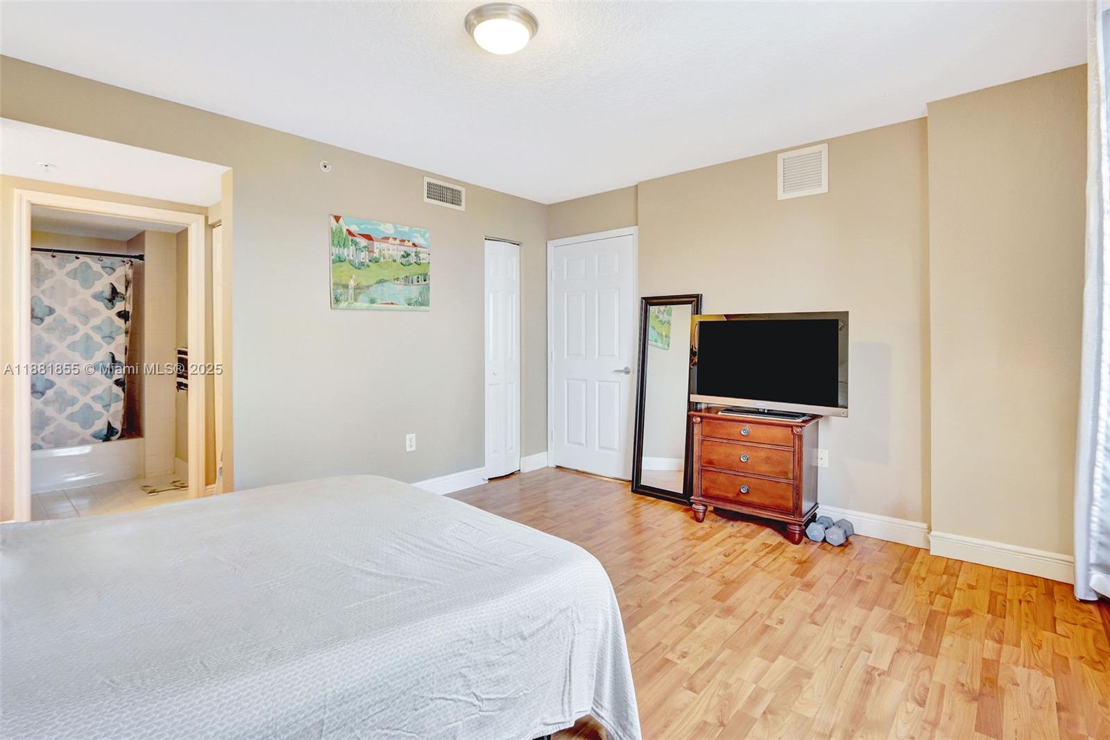 816 Northwest 11th Street, Unit 905 Miami, FL 33136 - Photo 6 of 14 a bedroom with a bed and a flat screen tv