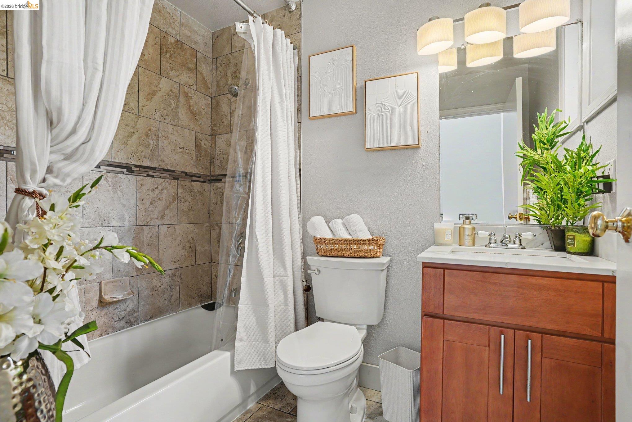 1433 Myrtle Street Oakland, CA 94607 - Photo 16 of 25 Bathroom featuring a wood-finish vanity with a white countertop, an integrated sink, and a multi-bulb light fixture above the mirror