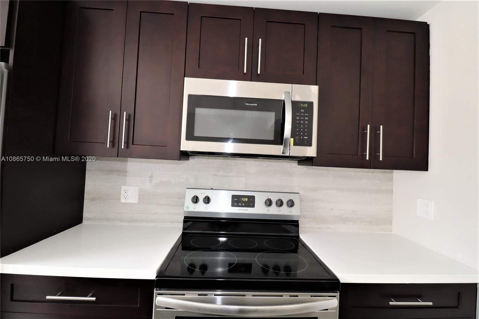 13966 Southwest 259th Terrace Homestead, FL 33032 - Photo 13 of 27 a kitchen with wooden cabinets and black appliances