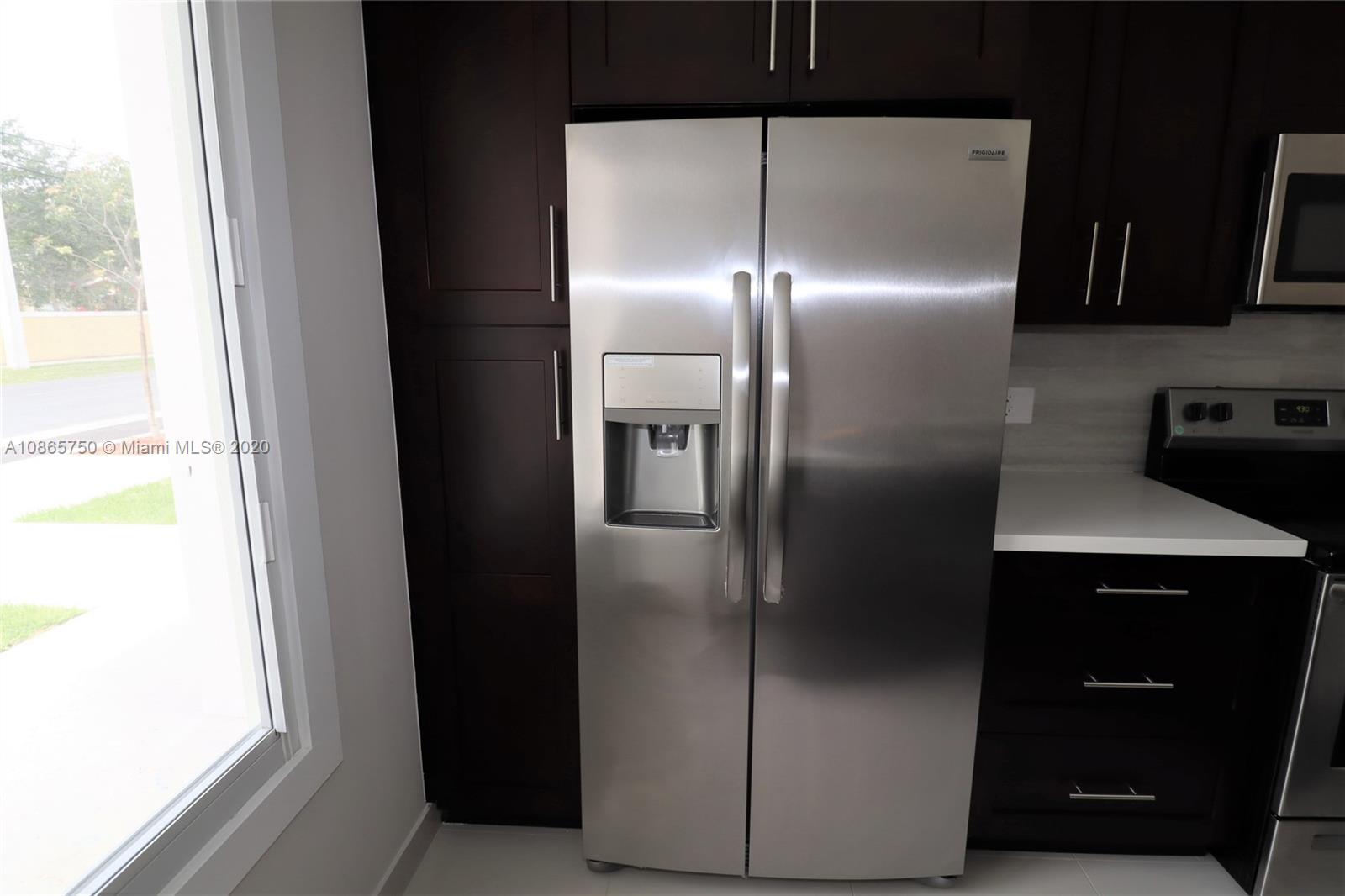13966 Southwest 259th Terrace Homestead, FL 33032 - Photo 14 of 27 a kitchen with metallic refrigerator freezer and a dishwasher