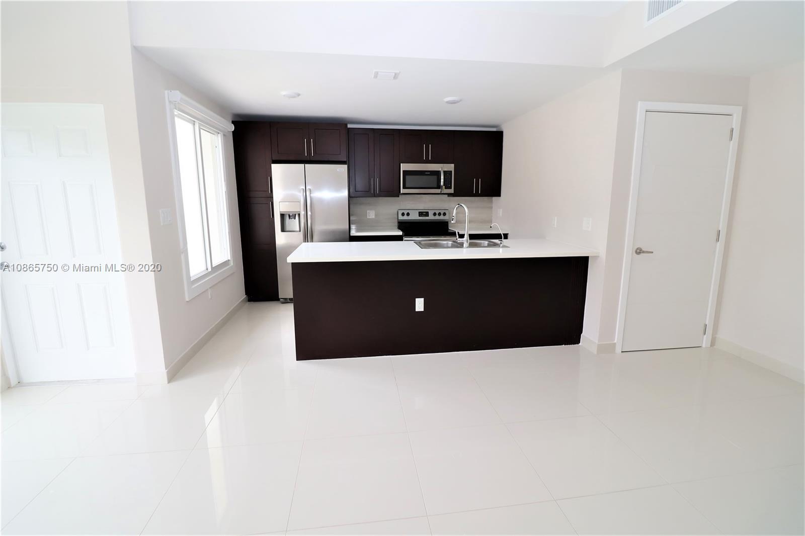 13966 Southwest 259th Terrace Homestead, FL 33032 - Photo 8 of 27 a living room with stainless steel appliances kitchen island a sink a stove a refrigerator cabinets and a window