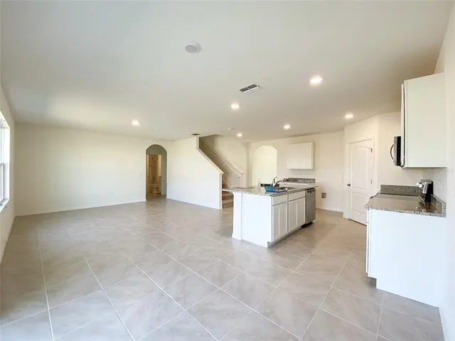 a large kitchen with a large counter top and stainless steel appliances