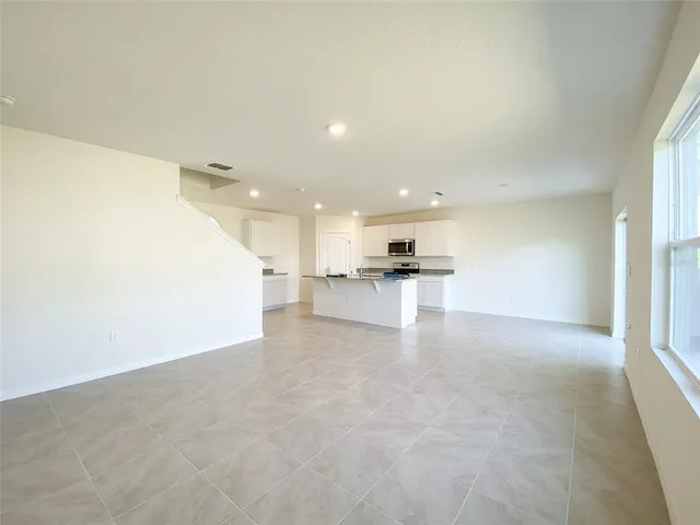 a view of kitchen with kitchen island white cabinets and refrigerator