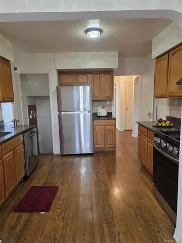 a kitchen with granite countertop a refrigerator stove top oven and sink