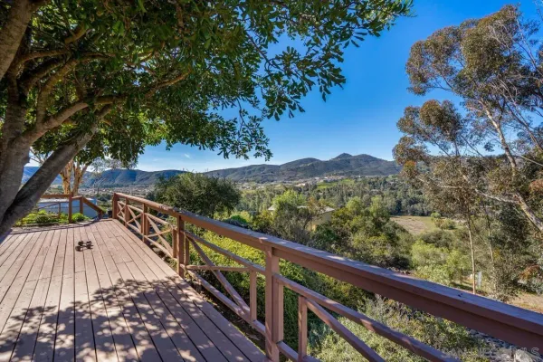a view of a balcony with wooden floor and fence