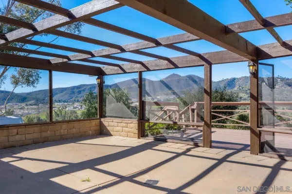 a view of a patio with a table and chairs under an umbrella