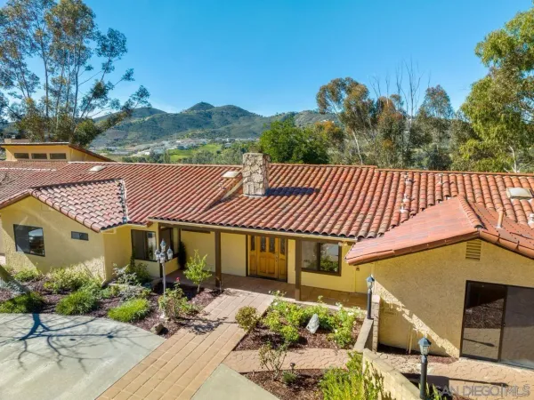 a front view of a house with garden and patio