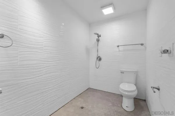 a bathroom with a toilet and a shower