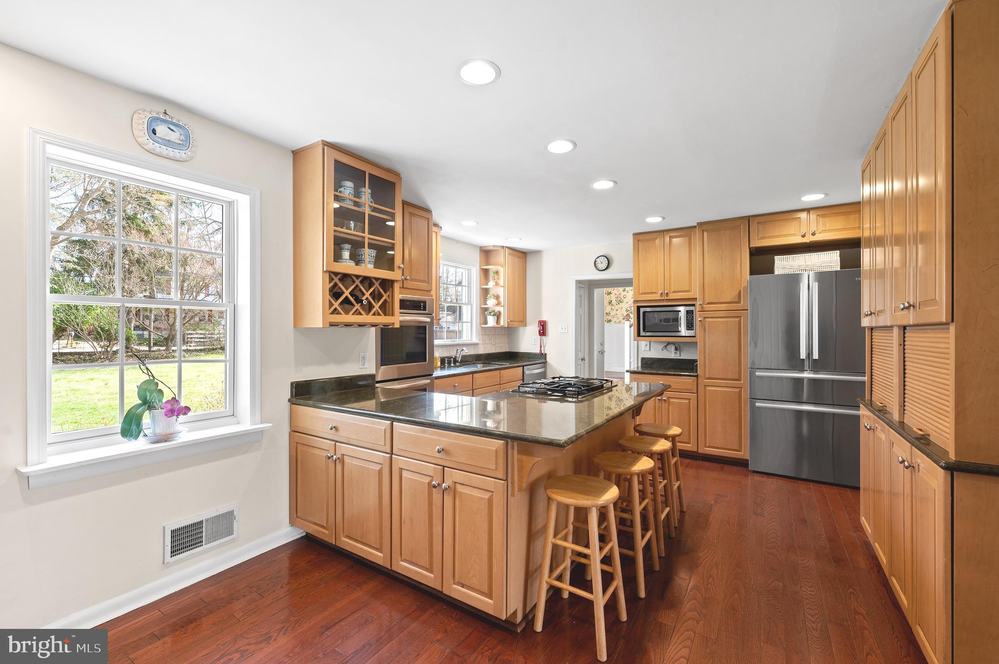 284 West Valley Road Wayne, PA 19087 - Photo 7 of 35 a kitchen with stainless steel appliances a stove a sink a refrigerator and wooden floor