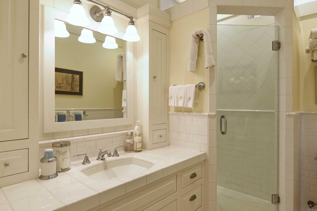441 Oceanview Terrace Encinitas, CA 92024 - Photo 13 of 34 a bathroom with a granite countertop shower sink and mirror