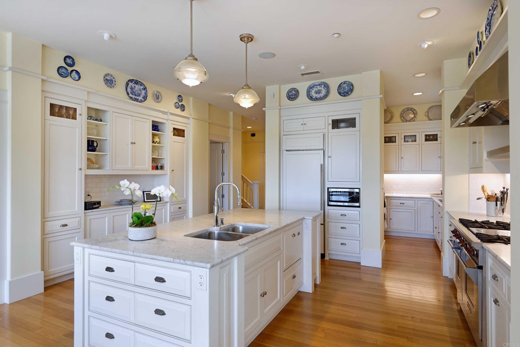 441 Oceanview Terrace Encinitas, CA 92024 - Photo 4 of 34 a large white kitchen with a refrigerator a sink and dishwasher