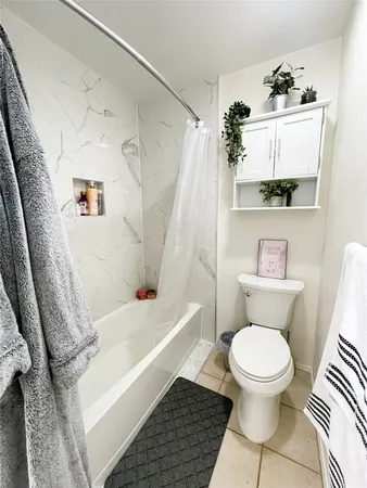a white toilet sitting next to a bath tub and a shower