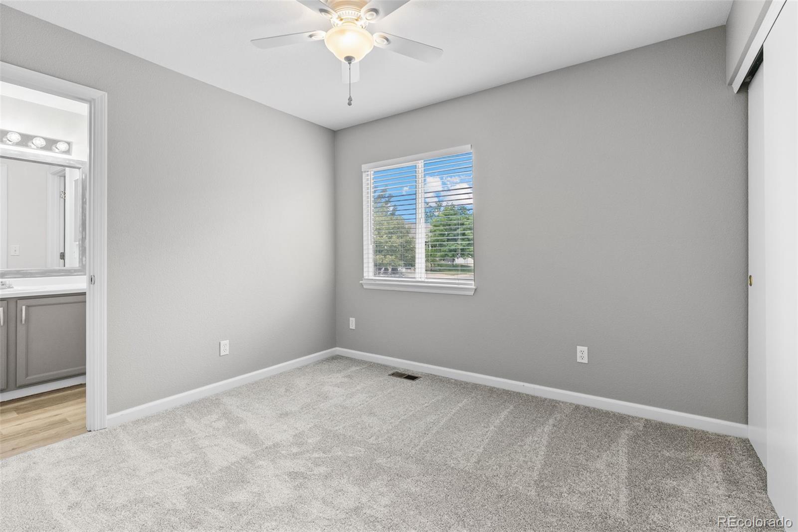 8743 Wildrye Circle Parker, CO 80134 - Photo 18 of 35 an empty room with a chandelier fan and windows