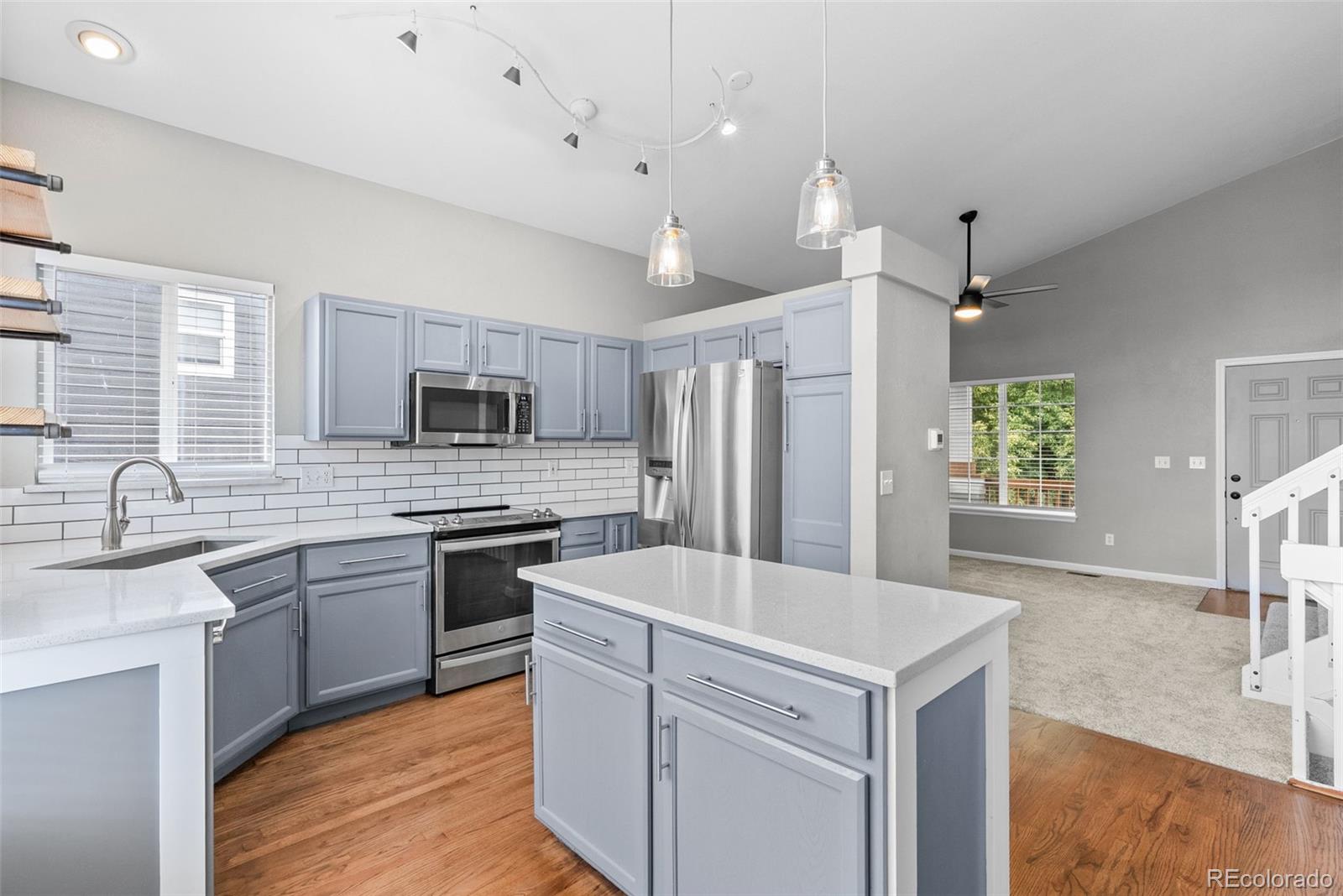 8743 Wildrye Circle Parker, CO 80134 - Photo 7 of 35 a kitchen with white cabinets and stainless steel appliances