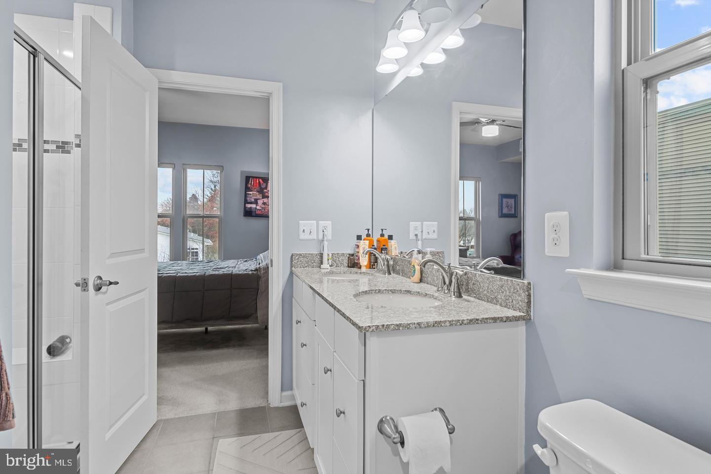 43821 Stubble Cor Square Ashburn, VA 20147 - Photo 17 of 25 a en suite bathroom with a granite countertop sink a toilet and a mirror