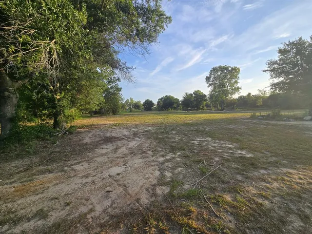 a view of yard with ocean and trees in the background