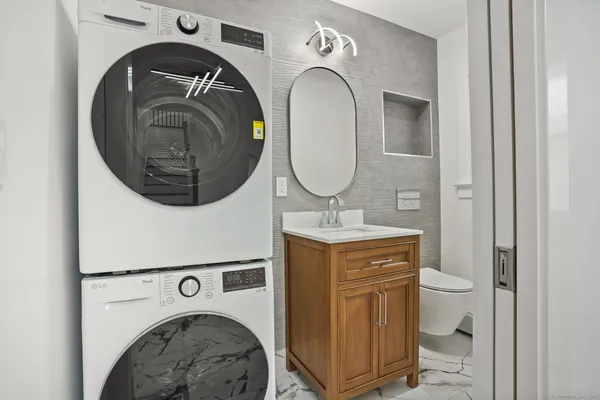 a bathroom with a granite countertop sink a toilet and shower