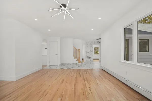 a kitchen with stainless steel appliances granite countertop a sink and cabinets with wooden floor