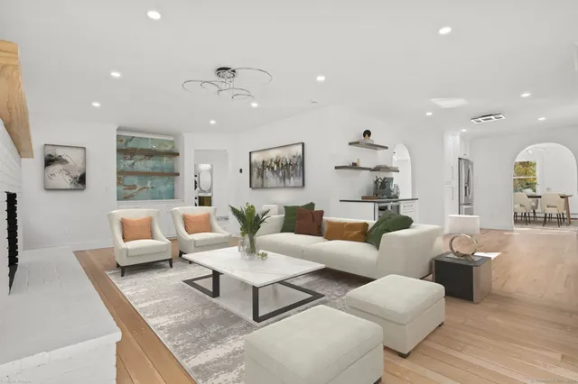 a large kitchen with stainless steel appliances a large counter top a stove a sink and a refrigerator