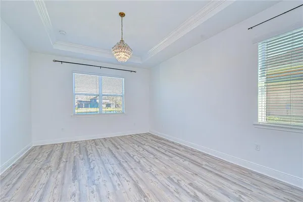 a view of empty room with wooden floor and ceiling fan