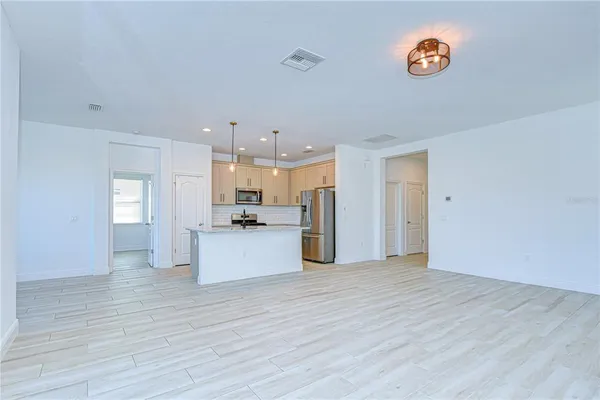 a view of kitchen with wooden floor and electronic appliances