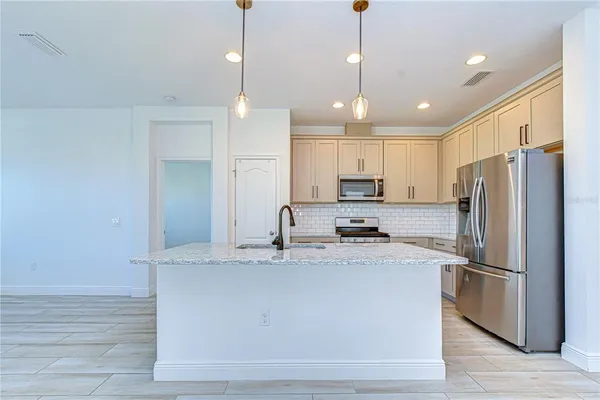 a kitchen with kitchen island a stove sink and cabinets