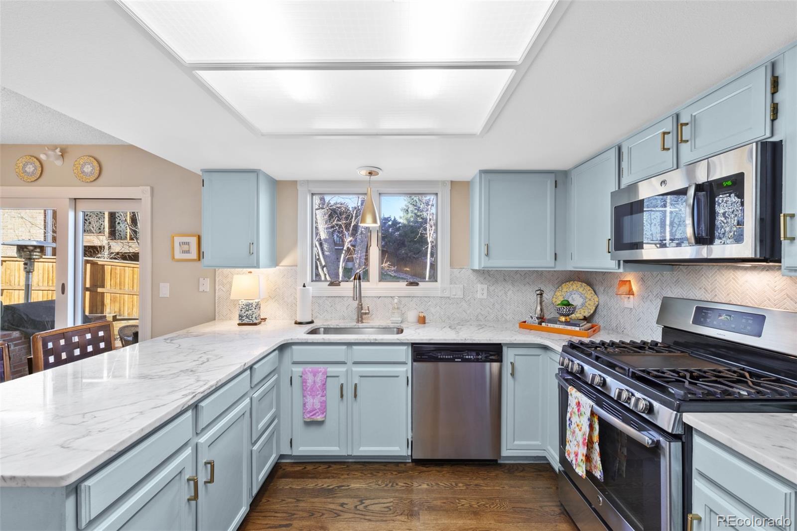 145 Willowleaf Drive Littleton, CO 80127 - Photo 12 of 42 a kitchen with stainless steel appliances granite countertop a sink stove and cabinets
