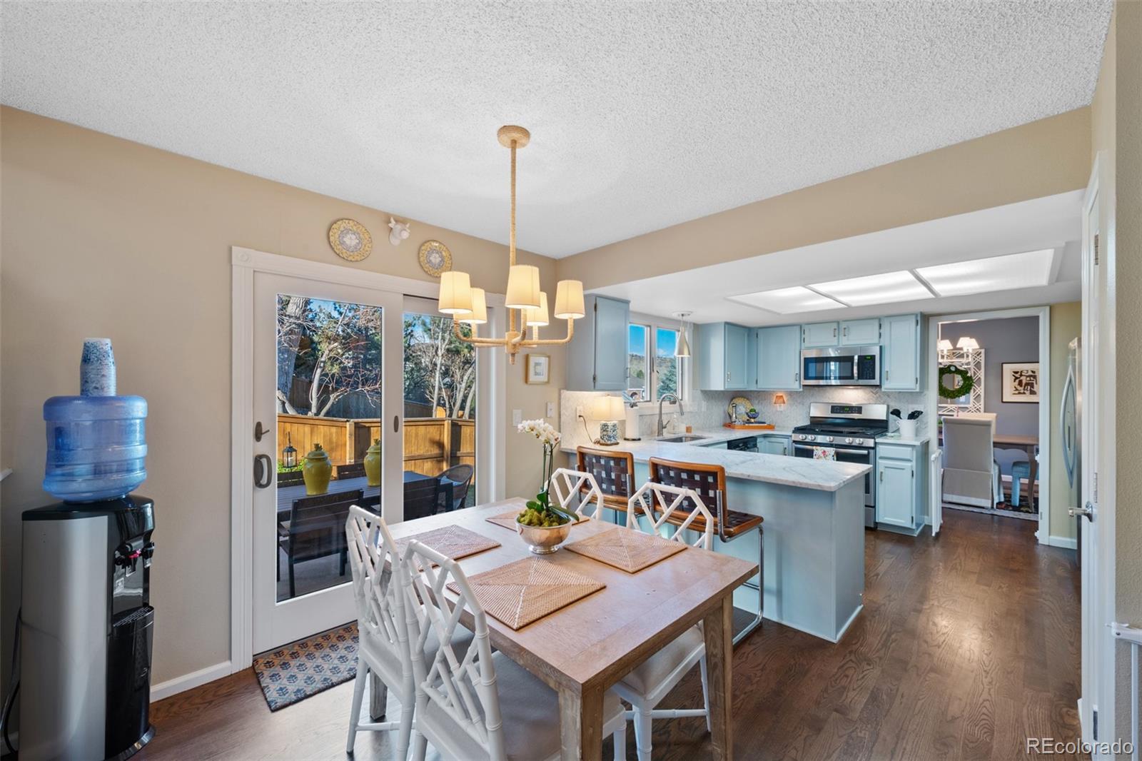 145 Willowleaf Drive Littleton, CO 80127 - Photo 14 of 42 a view of a dining room and livingroom with furniture wooden floor a rug a painting and a chandelier