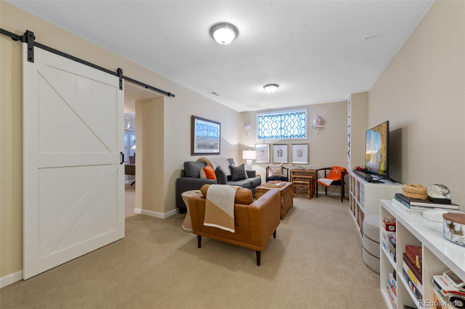 145 Willowleaf Drive Littleton, CO 80127 - Photo 31 of 42 a living room with furniture and a flat screen tv