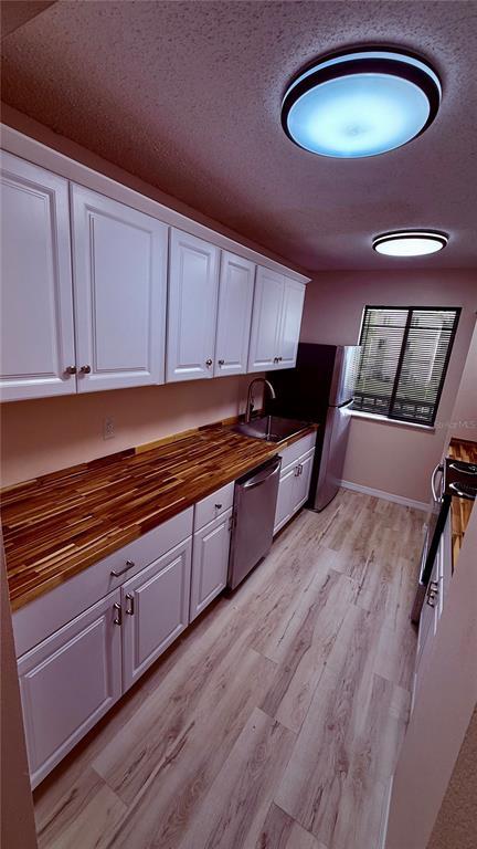 6519 West Newberry Road, Unit 206 Gainesville, FL 32605 - Photo 7 of 14 a kitchen with stainless steel appliances granite countertop a sink a stove and a wooden floors