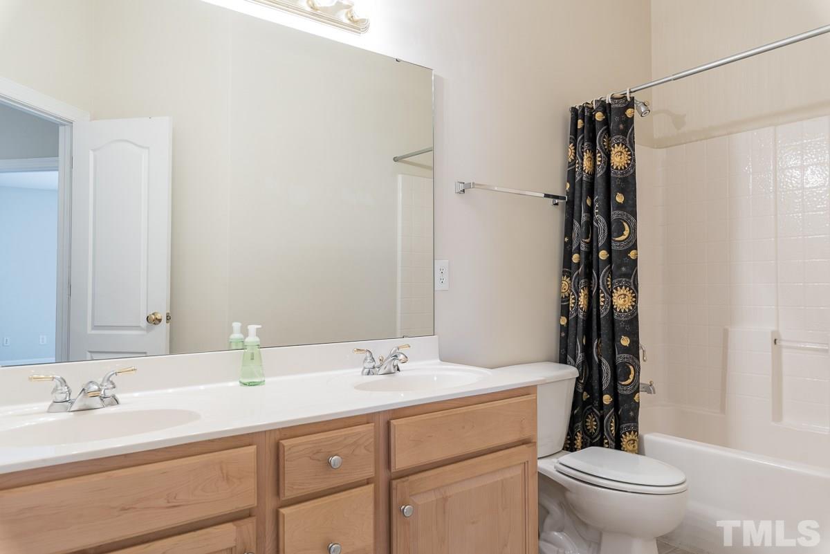 12227 Orchardgrass Lane Raleigh, NC 27614 - Photo 22 of 25 a bathroom with a sink a toilet and shower