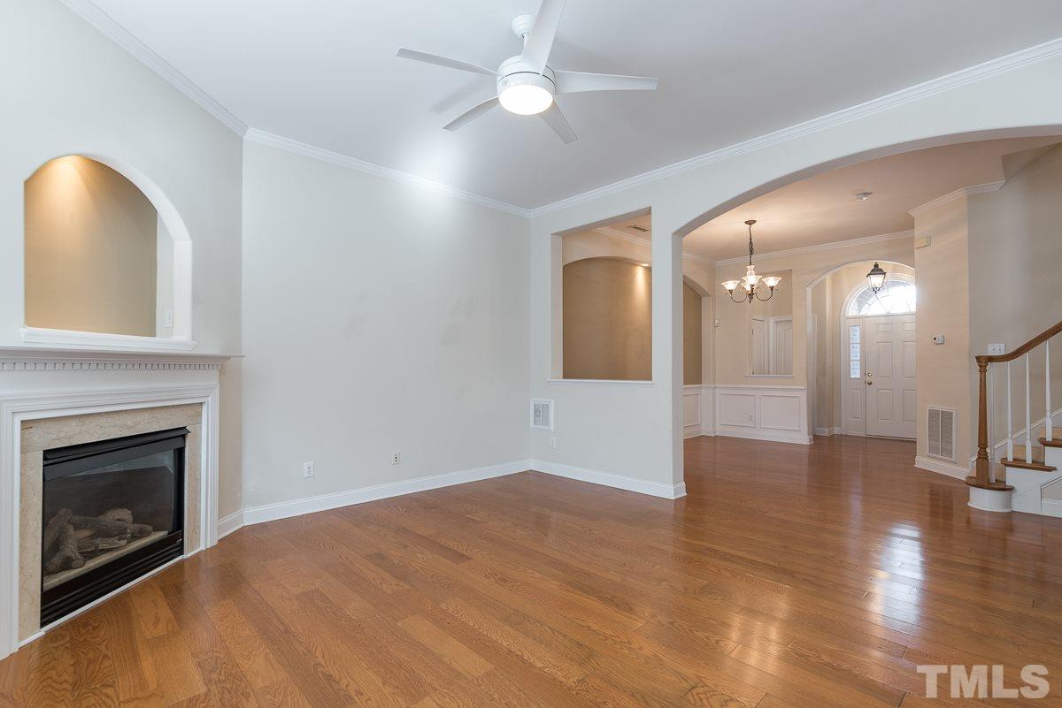 12227 Orchardgrass Lane Raleigh, NC 27614 - Photo 8 of 25 a view of an empty room with wooden floor and a fireplace