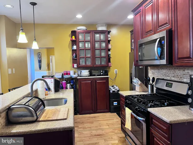 a kitchen with stainless steel appliances granite countertop a stove a refrigerator and a microwave