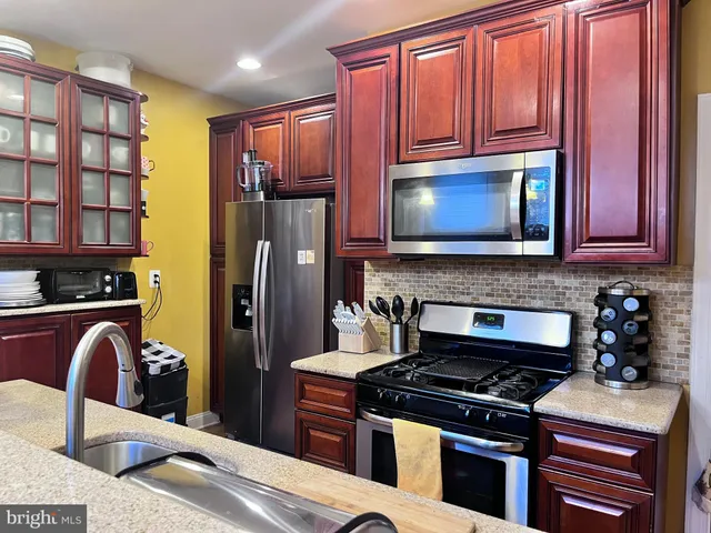 a kitchen with stainless steel appliances granite countertop a refrigerator stove top oven a sink and dishwasher