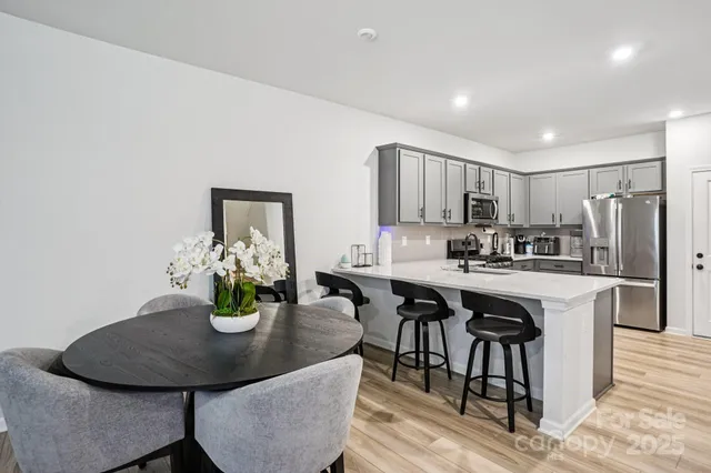 a kitchen with a dining table chairs and white cabinets