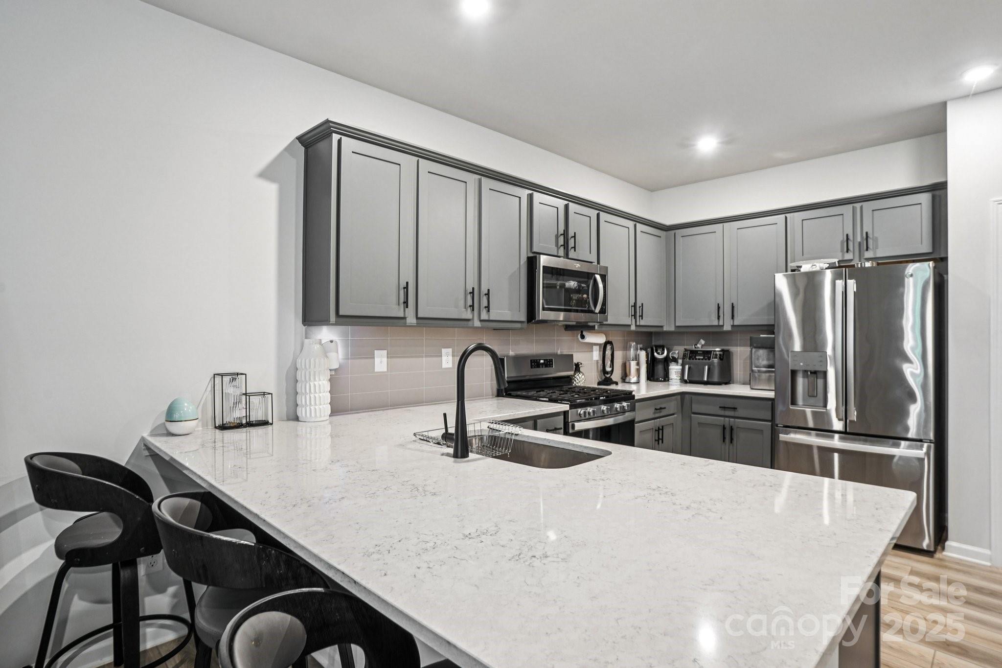 7914 Nelson Road Mint Hill, NC 28227 - Photo 7 of 25 a kitchen with granite countertop a refrigerator a stove a sink a stove a dining table and chairs