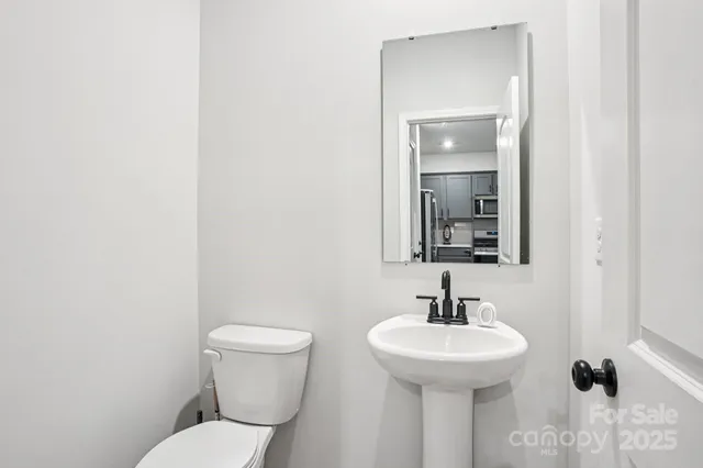 a bathroom with a toilet a sink and mirror