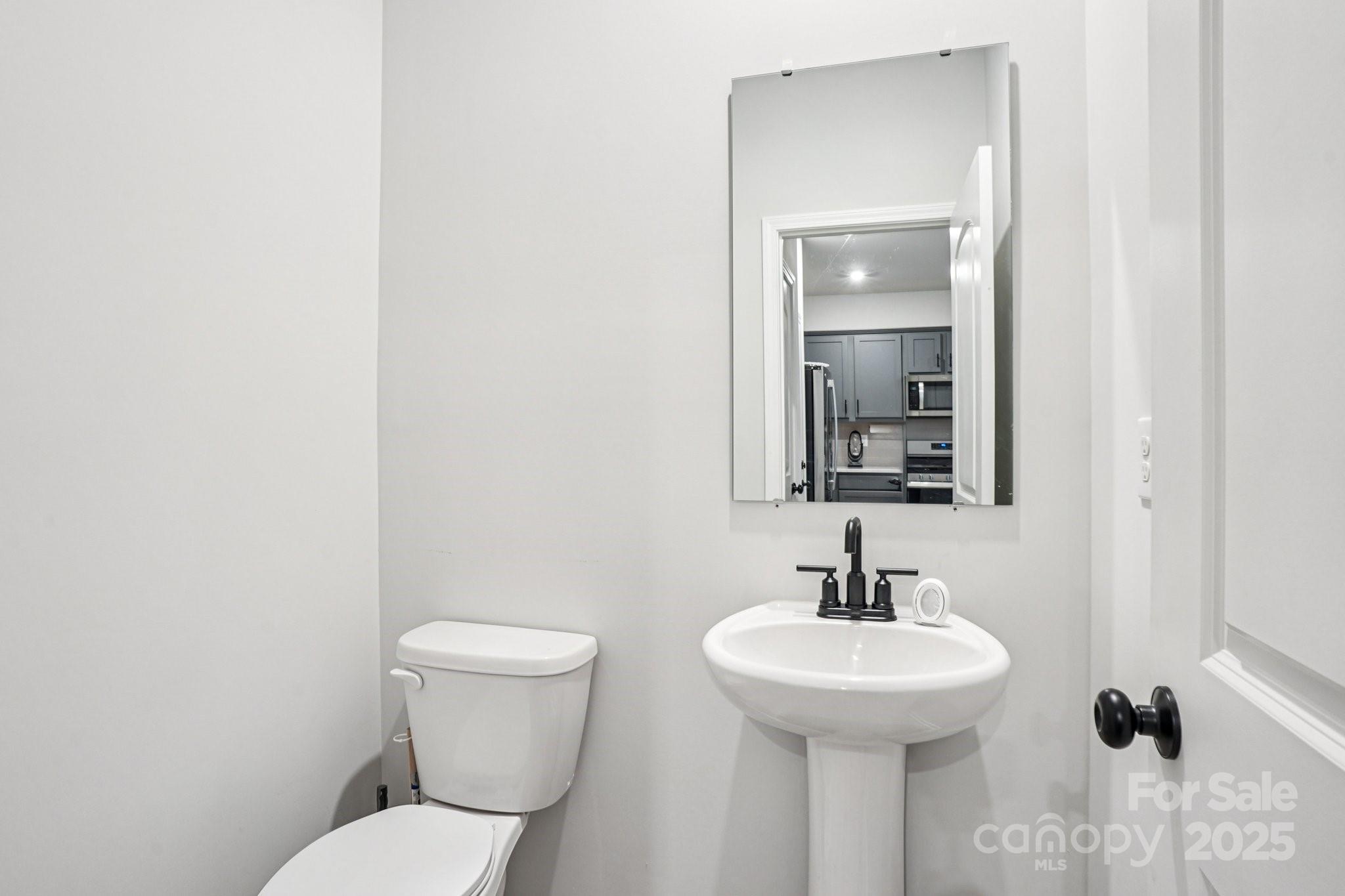 7914 Nelson Road Mint Hill, NC 28227 - Photo 9 of 25 a bathroom with a toilet a sink and mirror