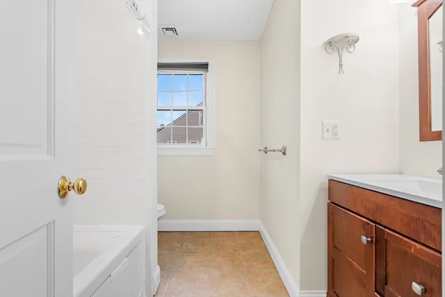 a bathroom with a tub sink and vanity