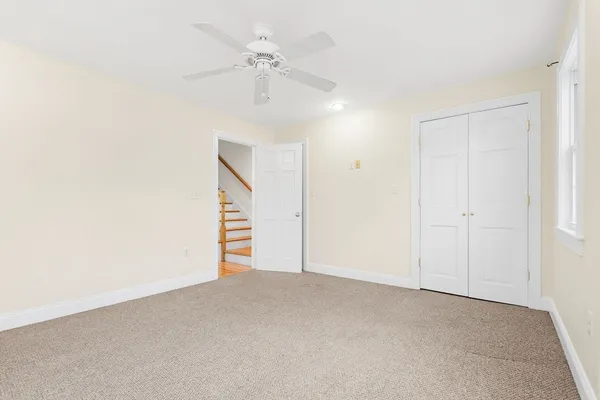an empty room with a ceiling fan and a window