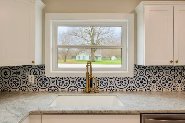 a kitchen with granite countertop white cabinets and sink
