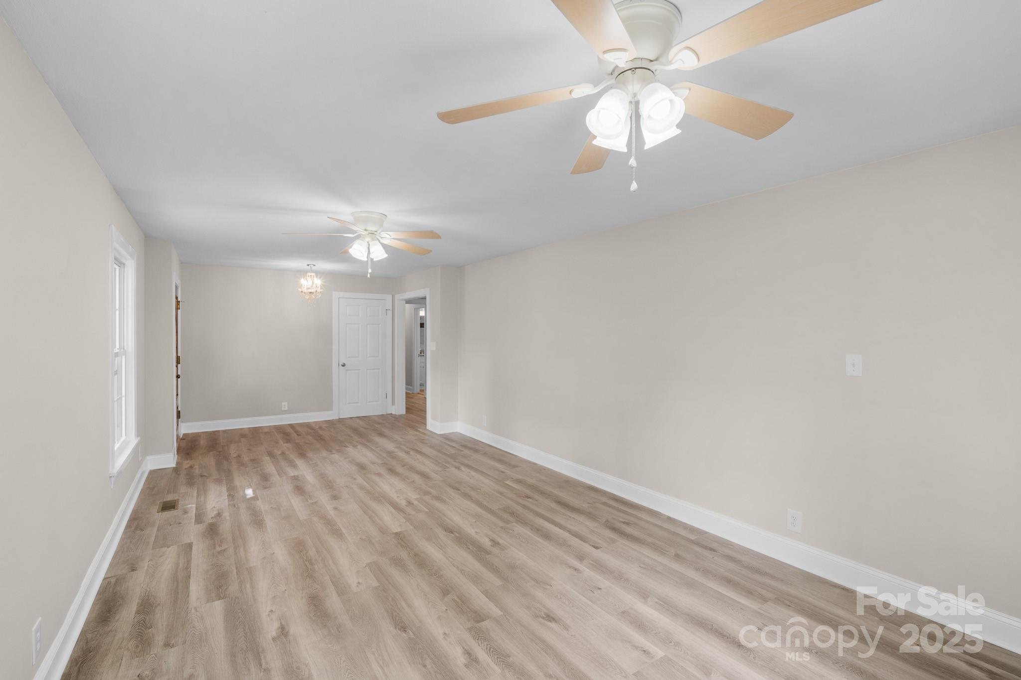 4355 Franklin Community Center Road Salisbury, NC 28144 - Photo 13 of 28 wooden floor in a hall with a chandelier fan