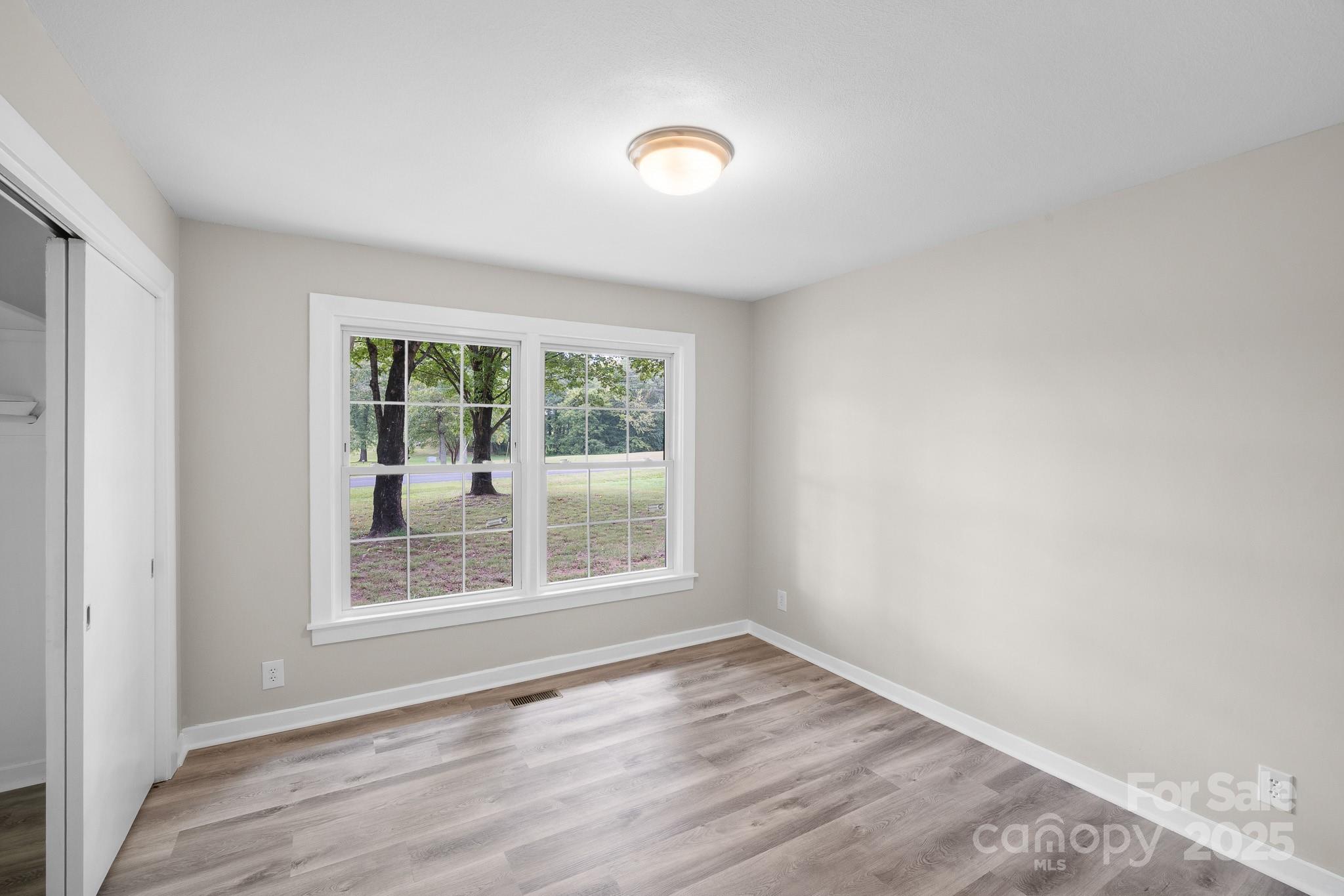 4355 Franklin Community Center Road Salisbury, NC 28144 - Photo 19 of 28 an empty room with wooden floor and windows