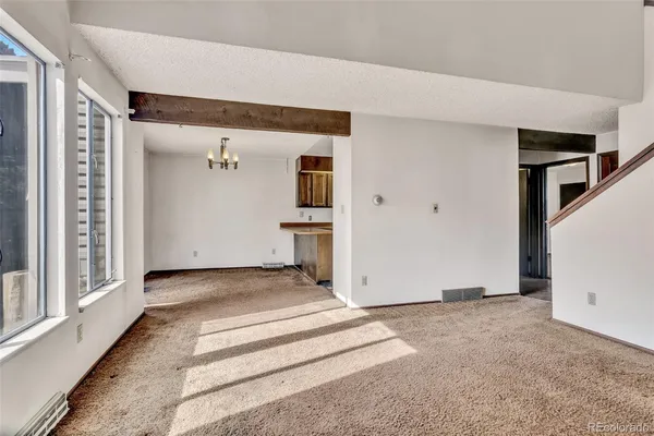 a view of a livingroom with wooden floor and stairs