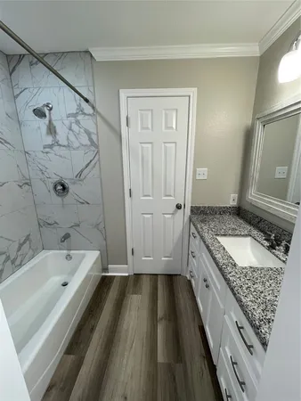 a bathroom with a granite countertop sink a toilet and bathtub