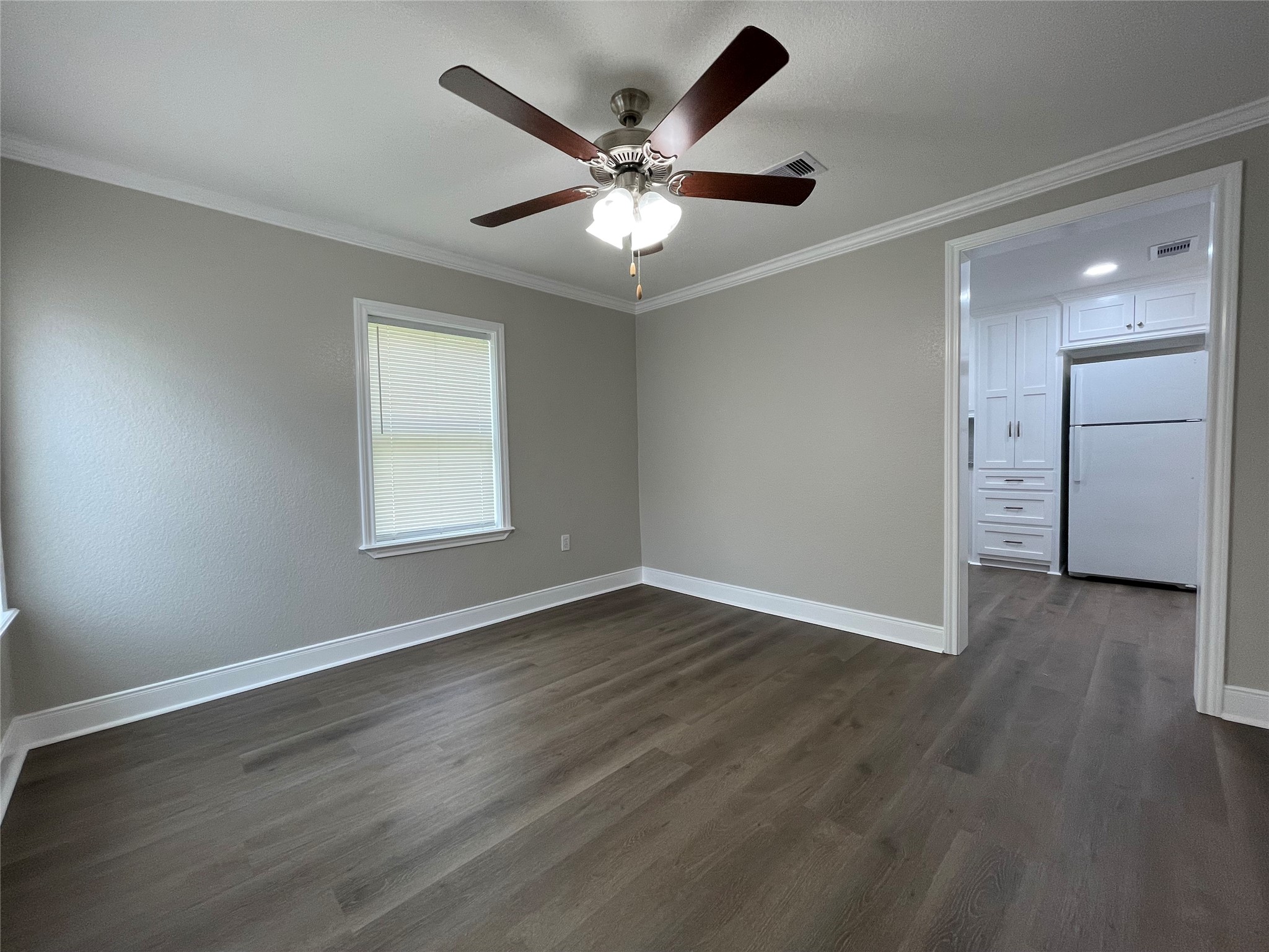 309 Ryan Street Angleton, TX 77515 - Photo 6 of 28 an empty room with wooden floor ceiling fan and windows